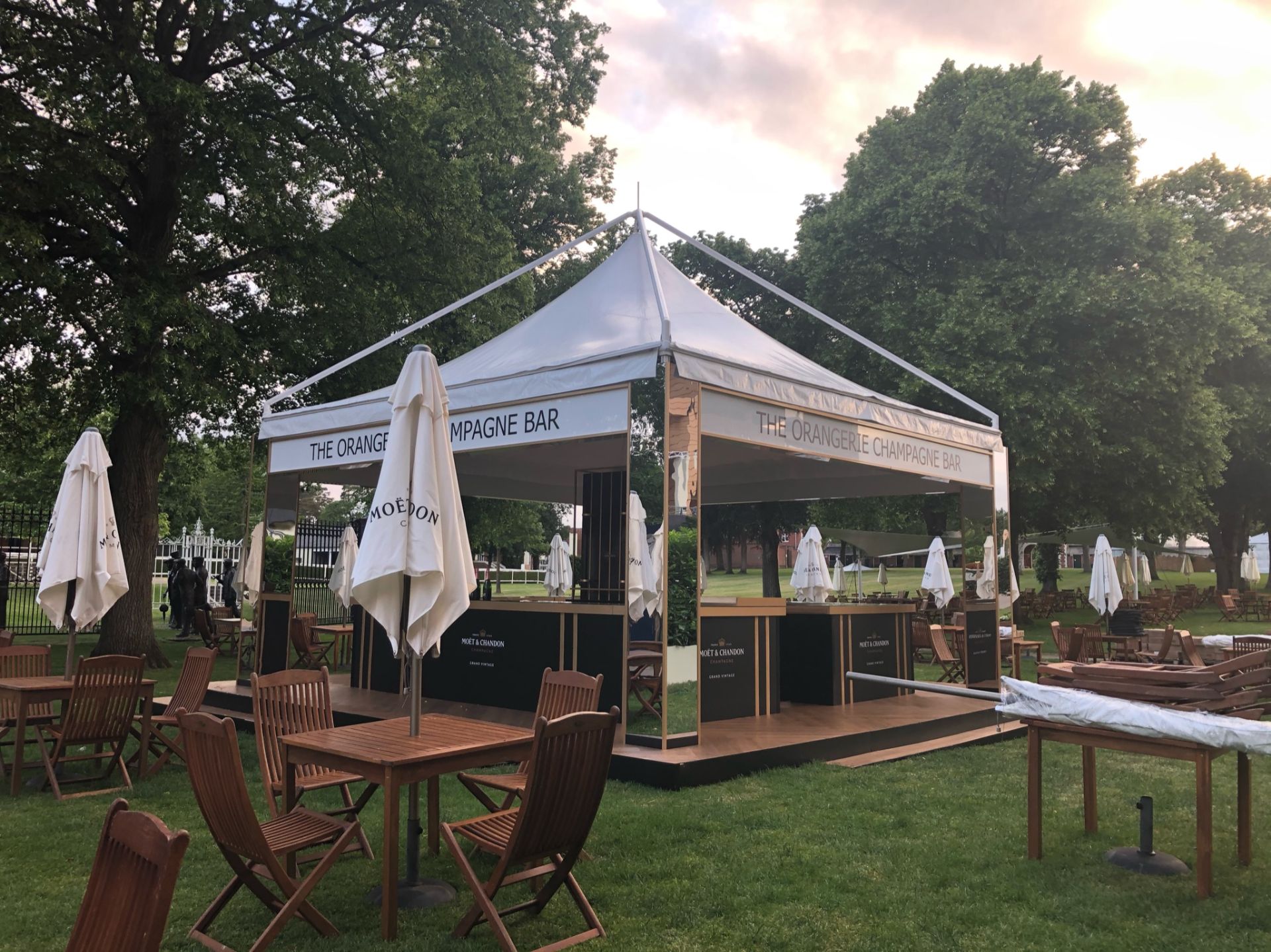 temporary event structure used as a bar, with wooden table and chairs surrounding