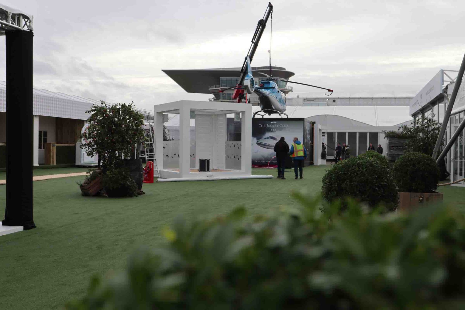 helicopter being lifted onto temporary event roof structure in the orchard at cheltenham festival