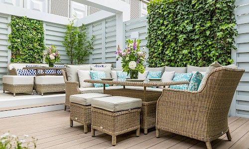 RHS Chelsea Flower Show rattan dining set with ivy collumns as partition in background